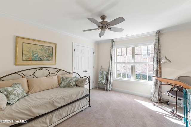 carpeted bedroom featuring crown molding, ceiling fan, and a closet