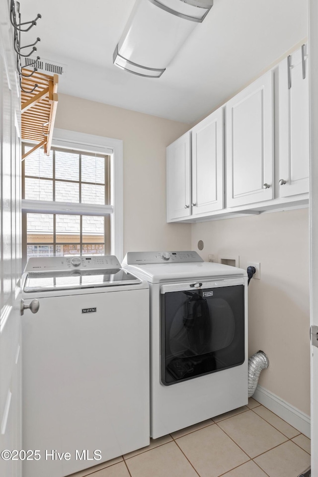 laundry room with separate washer and dryer, light tile patterned floors, and cabinets