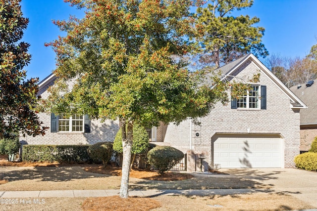 view of front facade featuring a garage, driveway, and brick siding