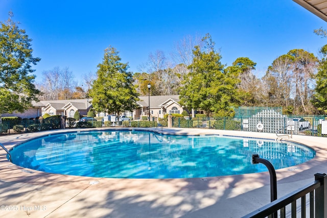 community pool featuring a residential view and fence