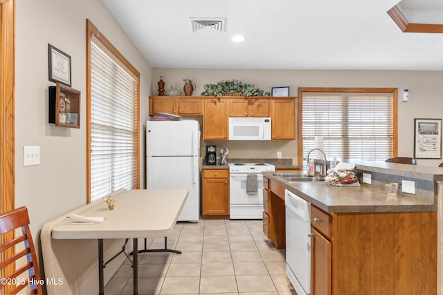 kitchen featuring sink, white appliances, a breakfast bar area, and light tile patterned flooring