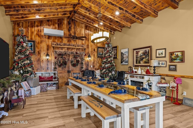 dining space featuring a wall mounted AC, wood walls, lofted ceiling with beams, and light wood-type flooring