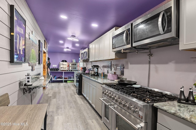 kitchen with white cabinets, light stone countertops, and stainless steel appliances