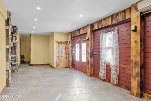 foyer featuring a wall unit AC and wooden walls