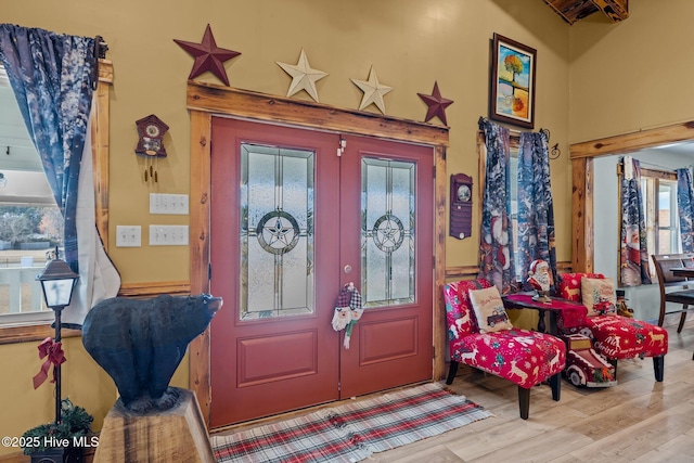 entryway with french doors, light hardwood / wood-style floors, and beam ceiling