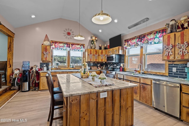 kitchen featuring a kitchen island, sink, appliances with stainless steel finishes, and tasteful backsplash