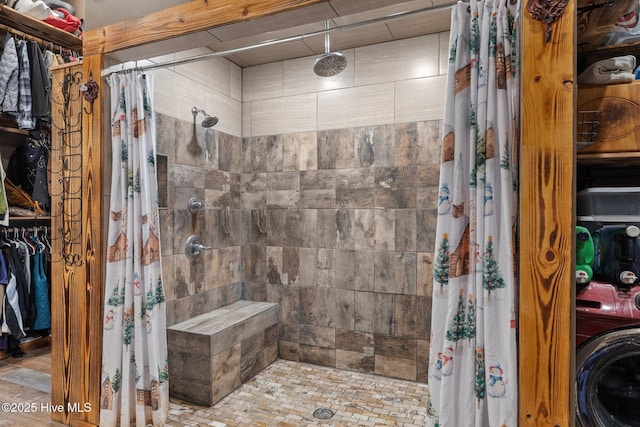 bathroom featuring a shower with shower curtain and washer / clothes dryer