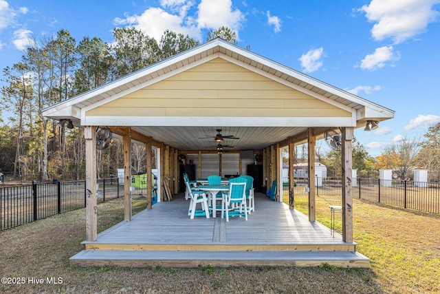 wooden terrace with ceiling fan and a yard