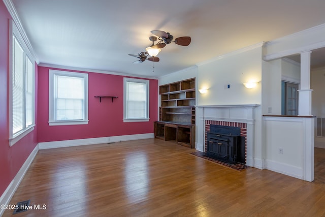 unfurnished living room with crown molding, baseboards, and wood finished floors