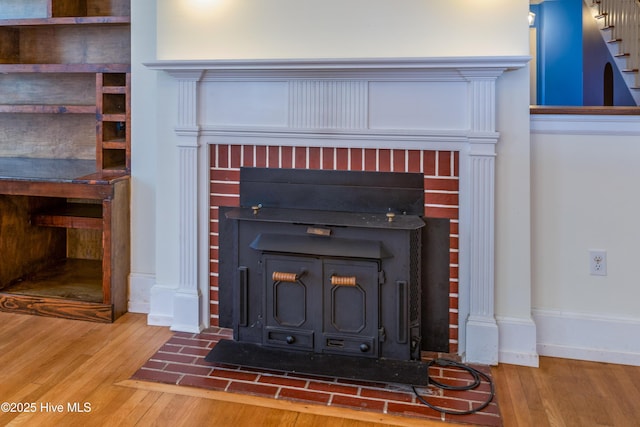 details featuring a wood stove, baseboards, and wood finished floors