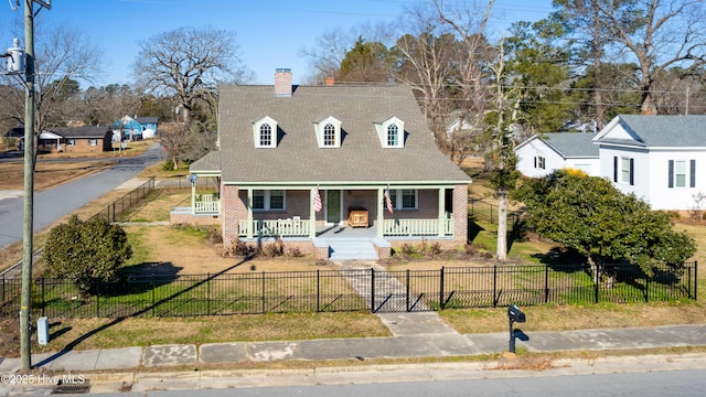 cape cod-style house with a fenced front yard, brick siding, covered porch, a front yard, and a gate