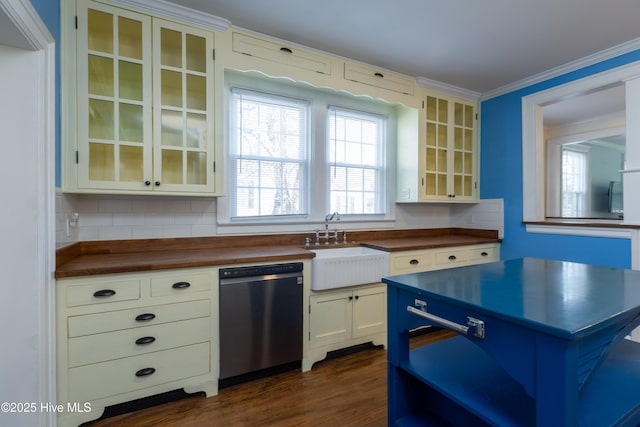 kitchen with a sink, ornamental molding, stainless steel dishwasher, decorative backsplash, and glass insert cabinets