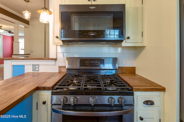 kitchen with stainless steel gas range oven, wood counters, crown molding, pendant lighting, and backsplash