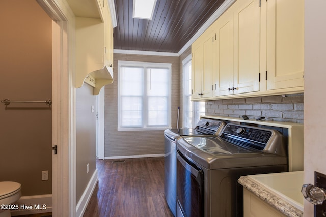 laundry room featuring laundry area, baseboards, dark wood finished floors, washing machine and clothes dryer, and crown molding