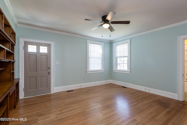 foyer entrance with visible vents, crown molding, and light wood-style flooring