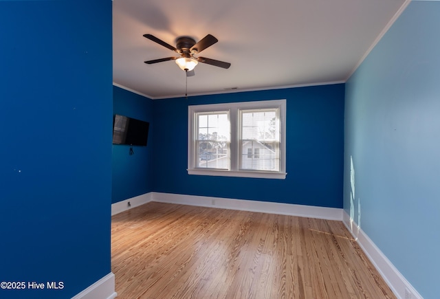 unfurnished room featuring ornamental molding, baseboards, and wood finished floors