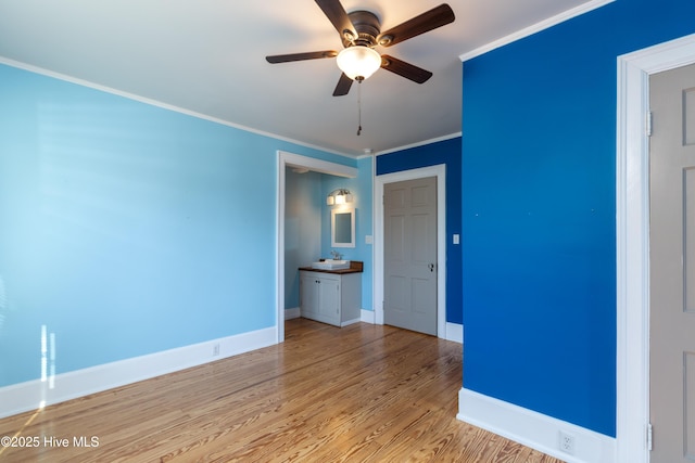 unfurnished room with baseboards, light wood-type flooring, a ceiling fan, and crown molding