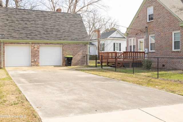 view of front of property featuring brick siding, fence, a front lawn, and roof with shingles