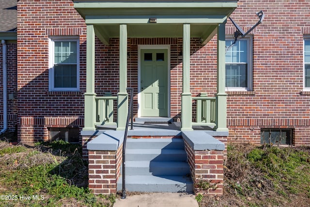 view of exterior entry with brick siding