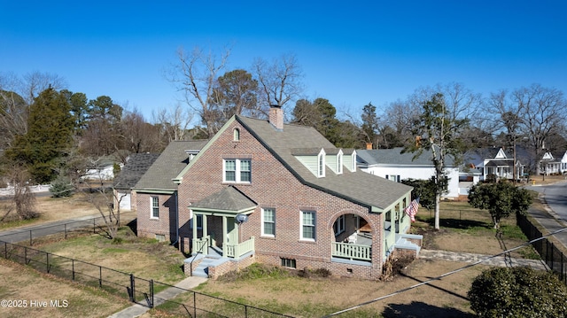 tudor house with fence private yard, a front lawn, and brick siding