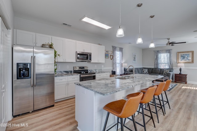 kitchen with white cabinetry, sink, ceiling fan, hanging light fixtures, and appliances with stainless steel finishes