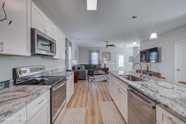 kitchen with white cabinets, hanging light fixtures, sink, and appliances with stainless steel finishes