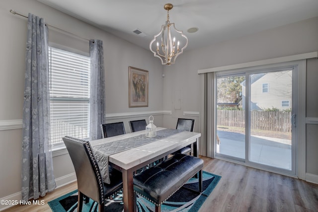 dining area featuring a notable chandelier and light wood-type flooring