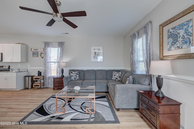 living room featuring light hardwood / wood-style flooring and ceiling fan