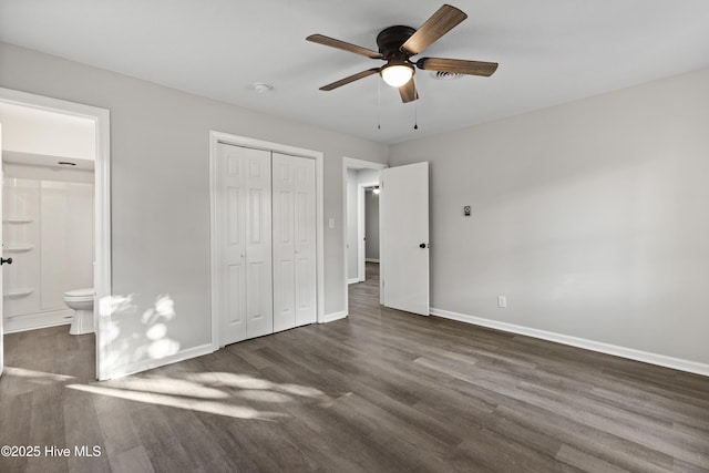 unfurnished bedroom featuring ensuite bathroom, a closet, ceiling fan, and dark hardwood / wood-style floors