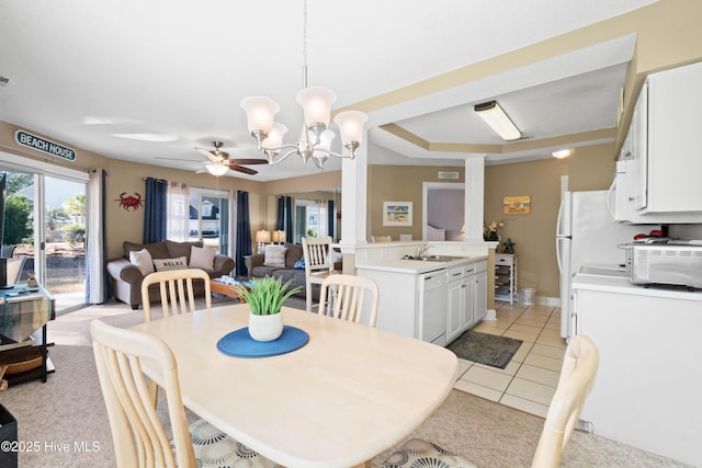 dining room with sink, light tile patterned floors, and ceiling fan with notable chandelier