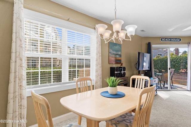 carpeted dining area featuring a notable chandelier