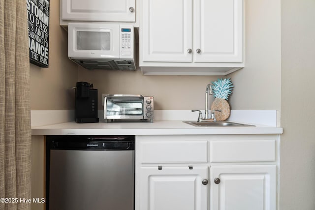 kitchen with white cabinetry, fridge, and sink