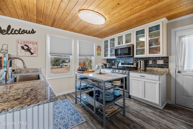 kitchen with appliances with stainless steel finishes, sink, wooden ceiling, dark stone countertops, and white cabinets