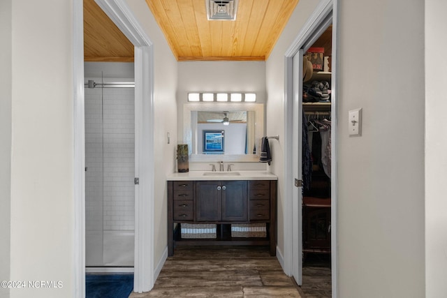 bathroom with hardwood / wood-style flooring, vanity, wood ceiling, and walk in shower