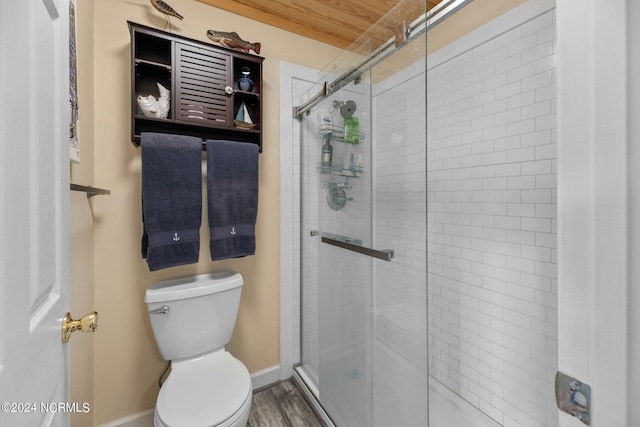 bathroom featuring hardwood / wood-style flooring, toilet, and an enclosed shower