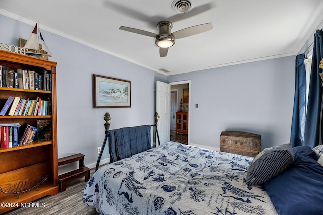 bedroom featuring ceiling fan, dark hardwood / wood-style flooring, and crown molding