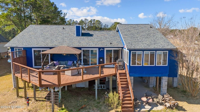 back of property featuring a deck and an outdoor hangout area