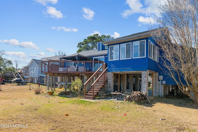 rear view of house with a wooden deck and a yard