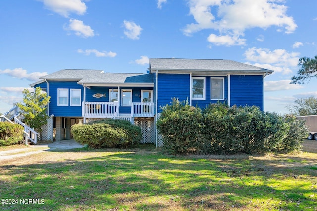 view of front of home featuring a front yard, a porch, and a carport