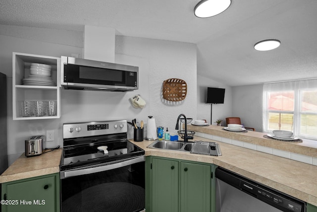 kitchen with stainless steel appliances, vaulted ceiling, exhaust hood, sink, and green cabinets