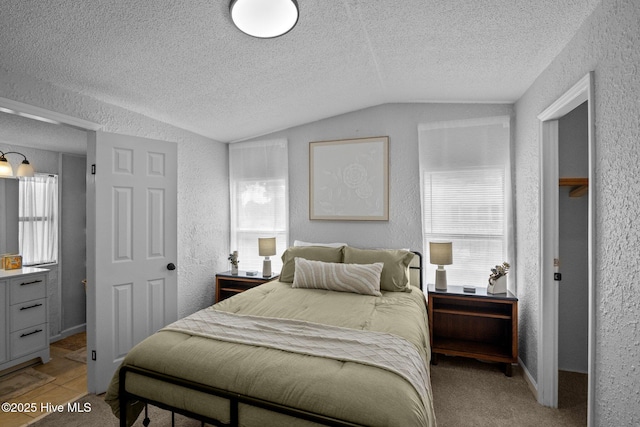 bedroom featuring a textured ceiling, light colored carpet, and lofted ceiling