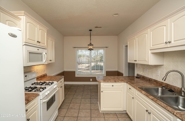 kitchen featuring a textured ceiling, white appliances, sink, decorative light fixtures, and light tile patterned flooring