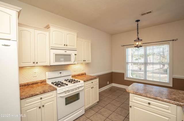 kitchen with white appliances, hanging light fixtures, tasteful backsplash, light tile patterned flooring, and white cabinetry