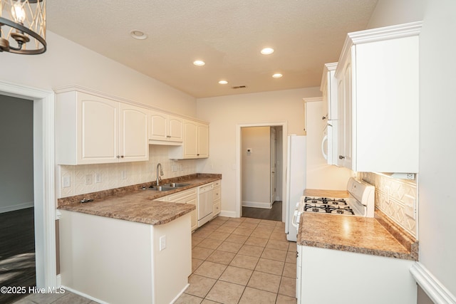 kitchen featuring white appliances, backsplash, white cabinets, sink, and light tile patterned flooring