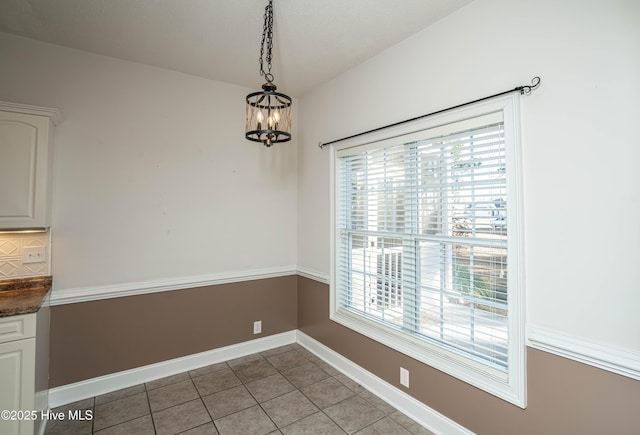 unfurnished dining area with light tile patterned floors and a notable chandelier