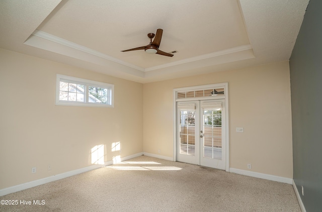 unfurnished room with carpet flooring, french doors, a tray ceiling, and ceiling fan