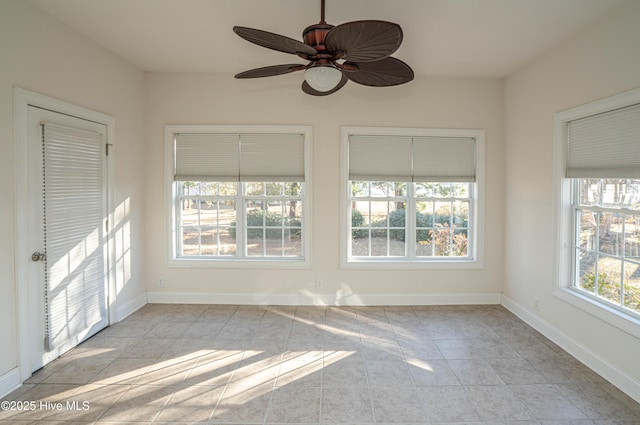 unfurnished sunroom with ceiling fan