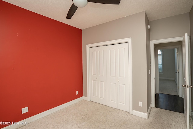 unfurnished bedroom featuring light carpet, a textured ceiling, a closet, and ceiling fan