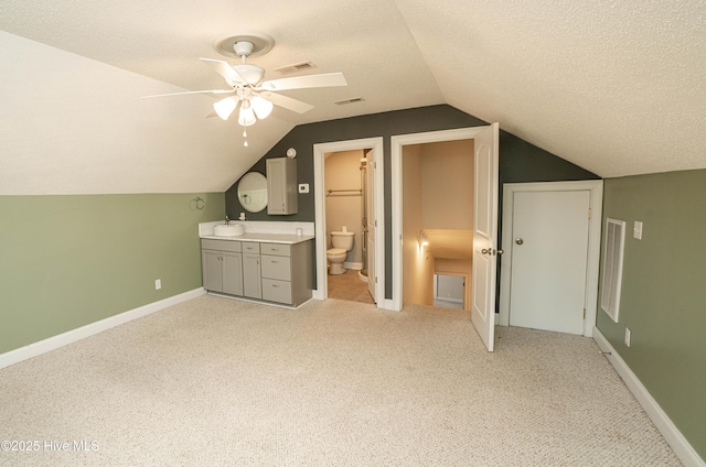 bonus room with a textured ceiling, light colored carpet, ceiling fan, and sink