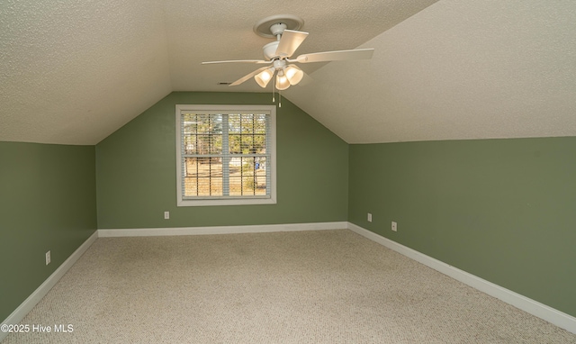 additional living space featuring carpet, ceiling fan, a textured ceiling, and vaulted ceiling